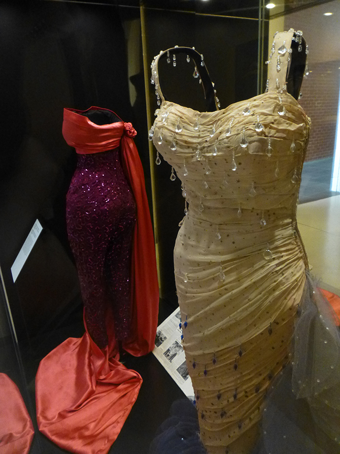 William (Jack) Travilla (1920-90), designer: (background) Sequinned pant suit and matching cloak (1955), silk, sequins, worn by Monroe in The Seven Year Itch (Billy Wilder, 1955) & (foreground) Evening gown (1954), silk, tulle, glass beads; Academy Award nominee for Best Costume Design (Colour, 1955), worn by Monroe in There's No Business Like Show Business (Walter Lang, 1954). (Colección Maite Minguez Ricart, Barcelona). Installation photo: Inga Walton.
